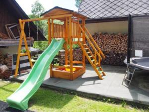 a playground with a green slide in a yard at Domeček Karlov in Malá Morávka