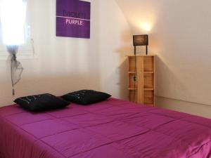 a bedroom with a purple bed with two pillows on it at Appartement Gruissan, 1 pièce, 6 personnes - FR-1-229-65 in Gruissan