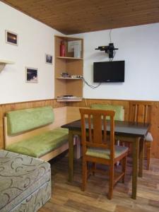 una habitación con una mesa y una silla y un televisor en Domeček Karlov, en Malá Morávka