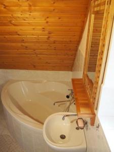 baño con bañera blanca y techo de madera en Domeček Karlov en Malá Morávka