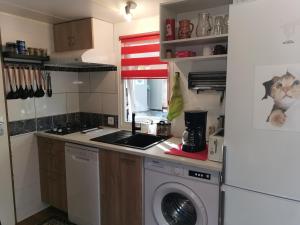 a kitchen with a washing machine and a washer at Mobil home - Clim, TV - Camping '4 étoiles' - Vic-la-Gardiole - 008 in Vic-la-Gardiole