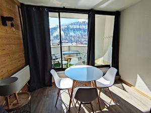 イゾラ 2000にあるAppartement Isola 2000, 2 pièces, 4 personnes - FR-1-292-64の大きな窓のある客室で、テーブルと椅子が備わります。
