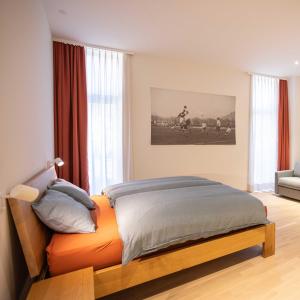 a bedroom with a bed with an orange bedspread at Locanda della Masseria a Porza, Lugano in Porza