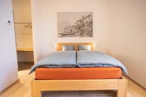 um quarto com uma cama com uma placa de pé laranja em Locanda della Masseria em Porza