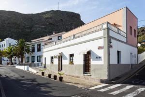 un edificio blanco al lado de una calle en El Hostal del Cubo en San Juan de la Rambla