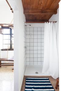 W łazience znajduje się prysznic z niebiesko-białym dywanem. w obiekcie El Hostal del Cubo w mieście San Juan de la Rambla