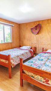 1 dormitorio con 2 camas y ventana en Cabañas Estrella del Sur, en Puerto Varas