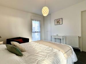 a bedroom with a bed and a chandelier at Appartement La Guérinière, 2 pièces, 2 personnes - FR-1-224B-171 in La Guérinière