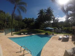 a swimming pool in a yard with palm trees at Jardin al Bosque-Glamping in San Juan