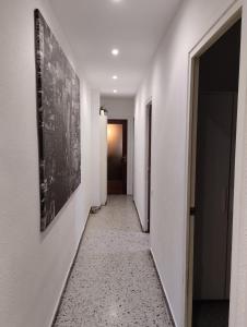 a hallway with white walls and a picture on the wall at Room Familiar nube paraiso in Barcelona