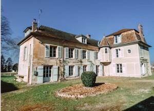 an old house with a tree in front of it at Le val en chêne in Choisy-au-Bac