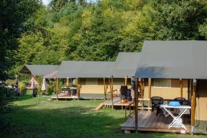Camping Bockenauer Schweiz في Bockenau: مجموعة أكواخ للتخييم مع طاولات وكراسي