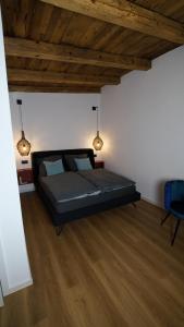 a bedroom with a black bed in a room with wood floors at Remise Brasch - Zwischen Bahnhof und Elbe in Wittenberge