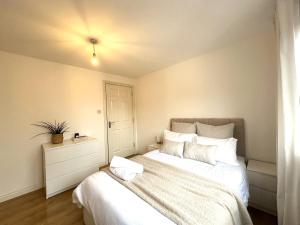 um quarto com uma cama grande e lençóis brancos em Private room with en-suite and parking in shared flat em Glasgow