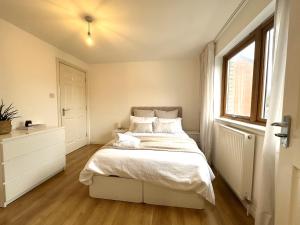 een slaapkamer met een bed en een raam bij Private room with en-suite and parking in shared flat in Glasgow