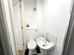 een witte badkamer met een toilet en een wastafel bij Private room with en-suite and parking in shared flat in Glasgow