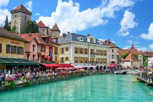 a group of people sitting around a river in a town at Annecy Élégance in Meythet