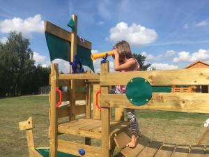 a young girl is standing in a playset at Domek nad jeziorem in Izdebno +18 photos
