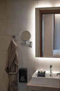 bagno con lavandino, specchio e asciugamano di IRA - ΗΡΑ City Hotel a Kalamáta