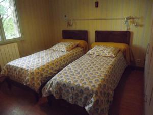 - deux lits assis l'un à côté de l'autre dans une pièce dans l'établissement Bienvenue à La Noyeraie, à Bio
