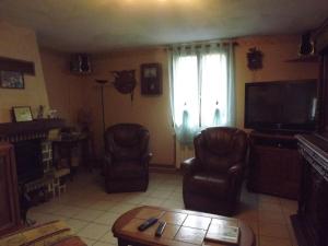 - un salon avec deux chaises et une télévision dans l'établissement Bienvenue à La Noyeraie, à Bio