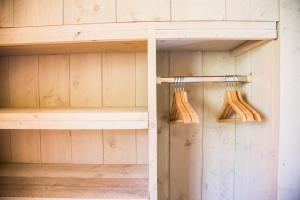 two wooden utensils are hanging in a closet at Cottage de Luxe in Harderwijk