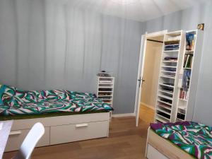 ein Schlafzimmer mit einem Bett und einem Bücherregal in der Unterkunft Paris Bécon in Asnières-sur-Seine