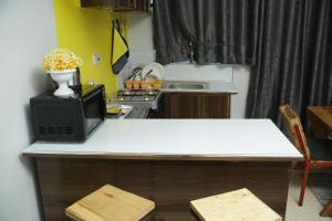 a kitchen with a counter with a microwave and a table at Enn lovely apartment 11 in Bungoma