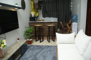 a living room with a white couch and a kitchen at Enn lovely apartment 11 in Bungoma