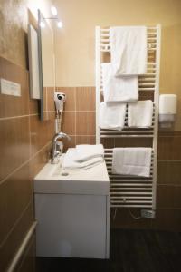 a bathroom with a sink and a mirror and towels at Le Victor Hugo - Hôtel et Restaurant - Logis Hôtels in Saint-Céré