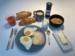 a table with a plate of food with eggs and bread at NOUVEAU - Ecolodge avec piscine au Golf-Plage de Biscarrosse - Couchage 2 adultes - Petit-déjeuner compris in Biscarrosse