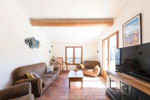 a living room with a couch and a tv at La Bastide des Milles in Apt
