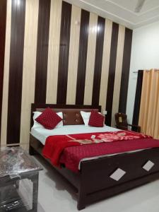 a bedroom with a large bed with red pillows at Ramam hotel by Naavagat Ayodhya in Ayodhya