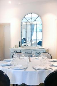 a table with a white table cloth and a mirror at Le Victor Hugo - Hôtel et Restaurant - Logis Hôtels in Saint-Céré