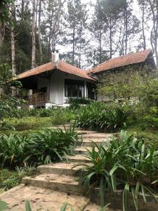 a small house in the middle of a garden at Kartika Lodge in Bengkok