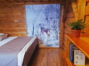 a bedroom with a bed and a deer outside a window at Penzión DolinkaGápel in Valaská Belá