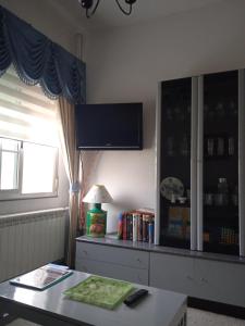 ein Wohnzimmer mit einem Tisch und einem Fernseher an der Wand in der Unterkunft CAMBOTE Vivienda turìstica in Lugo