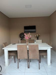 博尼圖的住宿－Casa com piscina，餐桌、椅子和花瓶