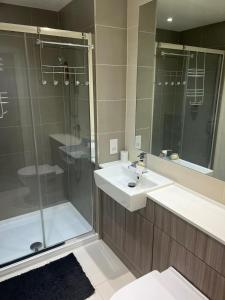 La salle de bains est pourvue d'un lavabo et d'une douche. dans l'établissement Stylish Colindale Apartment with Balcony, à Colindale