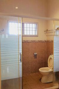 a bathroom with a toilet and a glass shower stall at Ipoh Sunway 20Pax 5 mins Lost World Holiday Home by City Home Empire in Tambun