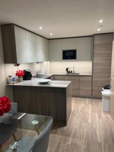 cocina con armarios de madera y encimera en Stylish Colindale Apartment with Balcony, en Colindale