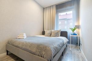 - une petite chambre avec un lit et une fenêtre dans l'établissement Apartament BIANCO w sercu Śląska, à Ruda Śląska