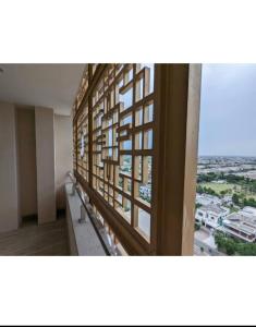 a room with a window with a view of a city at Gold crest Mall, The Aesthetic one bed suite in Lahore