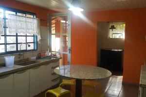 a kitchen with a table and some yellow stools at Estância Panorama in Palestina