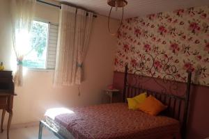 a bedroom with a bed with a floral wall at Estância Panorama in Palestina