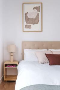 1 dormitorio con cama blanca y mesita de noche con lámpara en New Luxury flat next to Gran Vía en Madrid