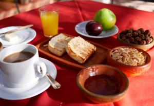 una mesa con un plato de comida y una taza de café en Hotel REAL CAFAYATE en Cafayate