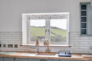 a kitchen with a sink and a window at Longpark Linhay in Paignton