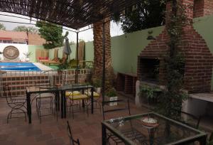 un patio con mesas y sillas y una chimenea de ladrillo en Hotel REAL CAFAYATE en Cafayate