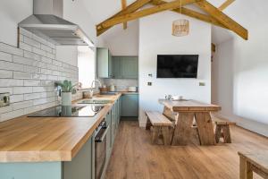 a kitchen with green cabinets and a wooden table at Longpark Linhay in Paignton